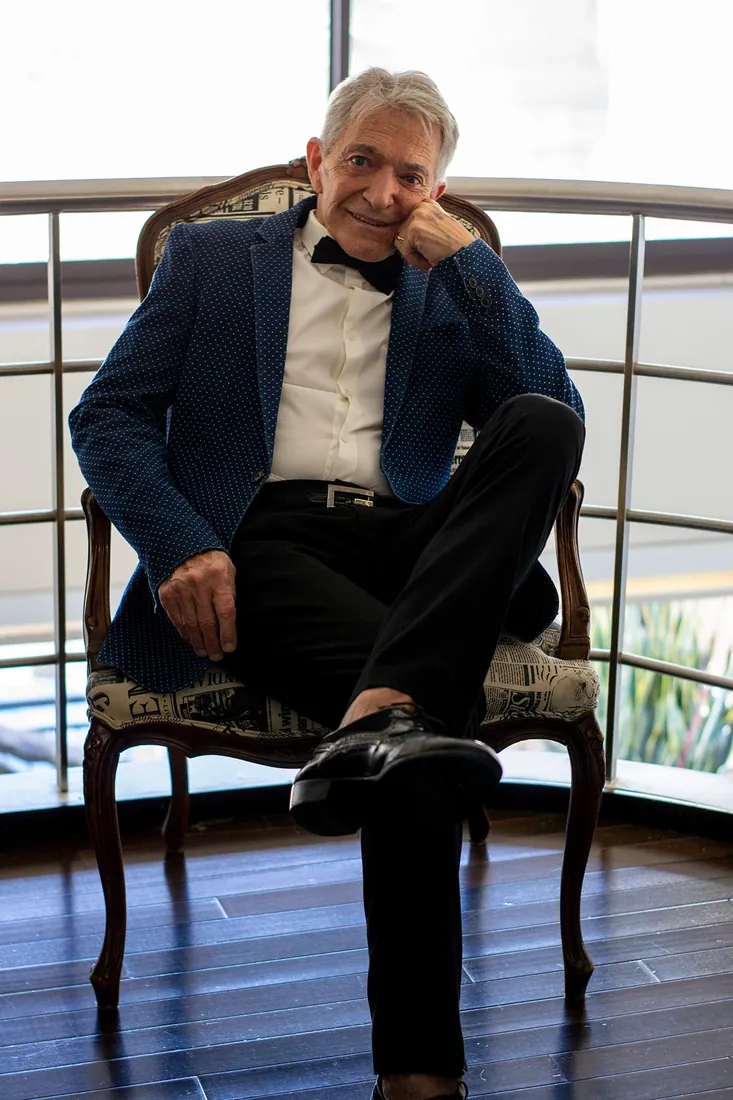 Hombre mayor sentado en un sillón antiguo junto a una ventana